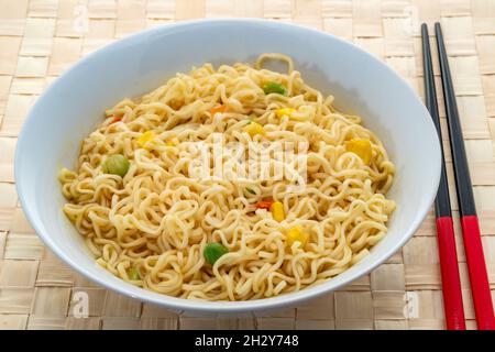 Nouilles au curry avec pois, maïs sucré et carottes. Banque D'Images