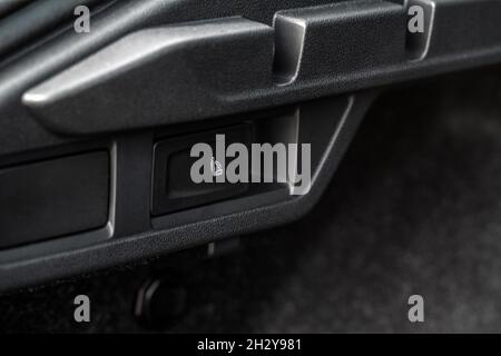 Bouton de rabattement de siège de deuxième rangée.Prise d'alimentation 12 V dans une voiture.Prise de courant dans une voiture. Banque D'Images