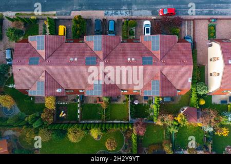 Vue aérienne des maisons mitoyennes équipées de panneaux solaires, trois maisons familiales avec jardins Banque D'Images