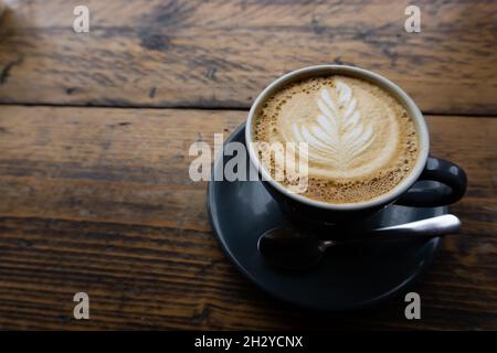 Cappucinno servi sur une table en bois dans la cafétéria, espace pour le texte Banque D'Images