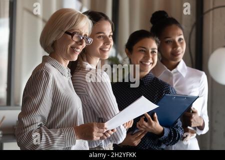 Les différentes équipes de femmes d'affaires se réunissent pour sourire prêt à rencontrer le client Banque D'Images