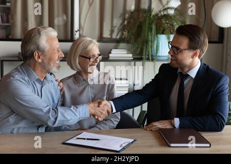 Un jeune homme souriant fait la liaison avec un couple de la famille de la vieillesse Banque D'Images