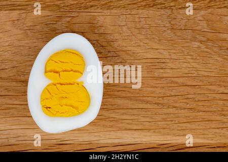 Figure huit oeuf coupé avec deux jaunes sur fond de bois, 8 mars concept de vacances Banque D'Images