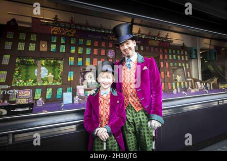 Willy Wonka (Ross Dawes) et Charlie (Troy Tipple) représentent un photocall devant une fabrique de chocolat en biscuit recréé par la comédie musicale West End et Biscuiteers, soutenus par Tate et Lyle, pour le 50e anniversaire de Charlie et de la chocolaterie Roald Dahl,Dans la vitrine Waterstones, Piccadilly, Londres. Banque D'Images