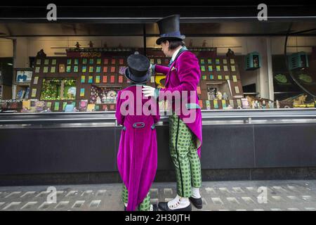 Willy Wonka (Ross Dawes) et Charlie (Troy Tipple) représentent un photocall devant une fabrique de chocolat en biscuit recréé par la comédie musicale West End et Biscuiteers, soutenus par Tate et Lyle, pour le 50e anniversaire de Charlie et de la chocolaterie Roald Dahl,Dans la vitrine Waterstones, Piccadilly, Londres. Banque D'Images