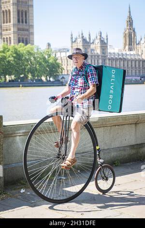 A Man livre de la nourriture pour Deliveroo sur un vélo Penny Farthing pendant la pandémie du coronavirus, Westminster, Londres.Date de la photo: Lundi 25 mai 2020.Le crédit photo devrait se lire: David Jensen/EMPICS Entertainment Banque D'Images