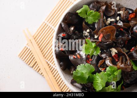 Salade de champignons noirs d'arbre mariné chinois dans un bol sur fond blanc.Vue de dessus.Copier l'espace. Banque D'Images