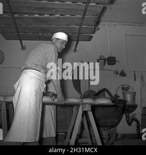 Ein Bäcker BEI seiner täglichen Arbeit, Deutschland 1950er Jahre.Un bakerman et son entreprise quotidienne, l'Allemagne des années 1950. Banque D'Images
