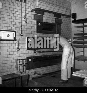 Ein Bäcker BEI seiner täglichen Arbeit, Deutschland 1950er Jahre.Un bakerman et son entreprise quotidienne, l'Allemagne des années 1950. Banque D'Images