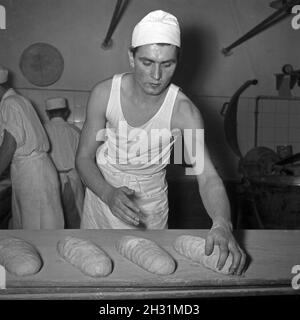 Ein Bäcker BEI seiner täglichen Arbeit, Deutschland 1950er Jahre.Un bakerman et son entreprise quotidienne, l'Allemagne des années 1950. Banque D'Images