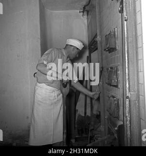 Ein Bäcker BEI seiner täglichen Arbeit, Deutschland 1950er Jahre.Un bakerman et son entreprise quotidienne, l'Allemagne des années 1950. Banque D'Images
