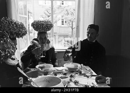 Eine Festtafel mit jungen Bräuten gekleidet in der traditionellen schwarzwälder Tracht mit dem Schäppel und ihren Bräutigamen, Deutschland 1930er Jahre.Un banquet avec de jeunes épouses portant la guirlande traditionnelle de la Forêt Noire avec le Schäppel et leurs grooms, Allemagne des années 1930. Banque D'Images