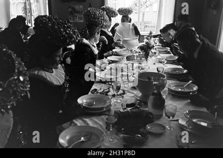 Eine Festtafel mit jungen Bräuten gekleidet in der traditionellen schwarzwälder Tracht mit dem Schäppel und ihren Bräutigamen, Deutschland 1930er Jahre.Un banquet avec de jeunes épouses portant la guirlande traditionnelle de la Forêt Noire avec le Schäppel et leurs grooms, Allemagne des années 1930. Banque D'Images