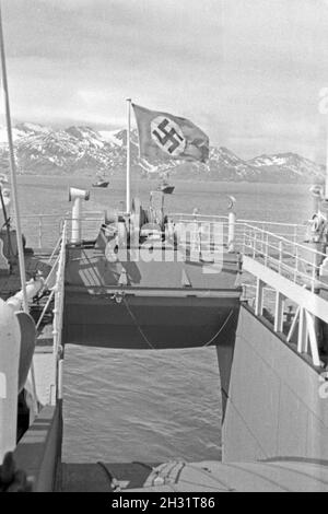 Hakenkreuzflagge im Wind suis Heck des Fabrikschiffs Walfang 'Jan Wellem' Inselgruppe vor einer im Eismeer der Burundi, 1930er Jahre. Drapeau à croix gammée dans le vent à l'arrière du navire-usine 'Jan Wellem' de la flotte baleinière allemand en face d'une montagne dans la mer de l'île de l'Antarctique, 1930. Banque D'Images