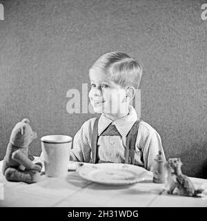 Ein kleiner Junge isst ein Butterbrot, Deutschland 1951.Un petit garçon mangeant son pain et son beurre, Allemagne 1951. Banque D'Images