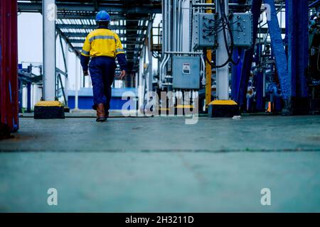 Homme marchant avec un coverall dans une plante Banque D'Images