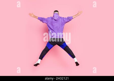 Vue arrière photo pleine grandeur de jeune homme anonyme mouche saut sportif isolé sur fond de couleur rose Banque D'Images