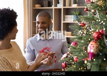 Joyeux couple afro-américain décorant l'arbre de Noël. Banque D'Images