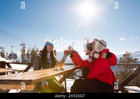 Groupe d'amis appréciant le vin chaud chaud au café de la station de ski. Banque D'Images