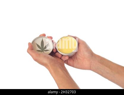 Concept cosmétique avec CBD.De belles mains femelles tiennent un pot avec un produit cosmétique avec une feuille de marijuana.Maquette de crème hydratante, cire, mais Banque D'Images