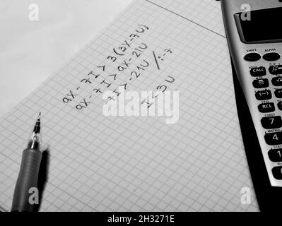 Stylo, calculatrice scientifique et papier avec une équation résolue Banque D'Images
