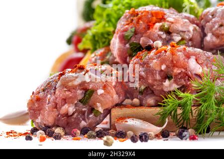 Boulettes de viande fraîches avec divers légumes sur fond blanc Banque D'Images