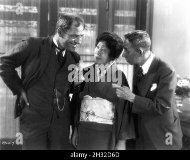 LON CHANEY sur le set Candid avec 2 visiteurs japonais non identifiés pendant le tournage de TANDIS QUE LA VILLE ACCUEILLE 1928 réalisateur JACK CONWAY Story / scénario Andrew Percival plus jeune costume design Gilbert Clark Metro Goldwyn Mayer Banque D'Images