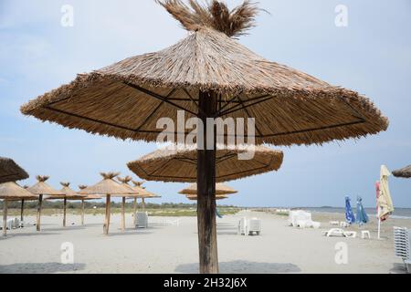 Gros plan d'un parasol de plage de paille contre un ciel bleu par une journée ensoleillée en Roumanie Banque D'Images