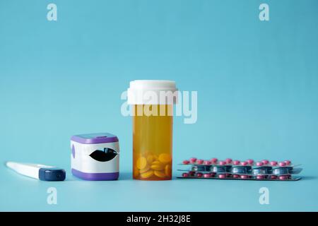 oxymètre de pouls, pilules médicales et blister sur fond bleu Banque D'Images