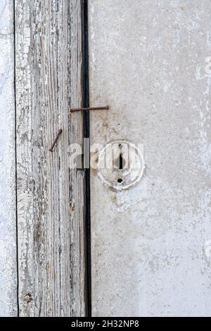 Flou artistique, bruit, flou, effet de grain.Fragment d'une ancienne porte d'entrée en bois.Porte avant abîmé avec peinture blanche fissurée.Mise au point sélective. Banque D'Images