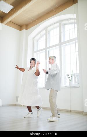 Une femme africaine heureuse dansant avec un homme âgé pendant une leçon de danse en studio Banque D'Images