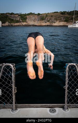 Homme sautant du bateau à voile dans l'océan à Rio de Janeiro, au Brésil Banque D'Images