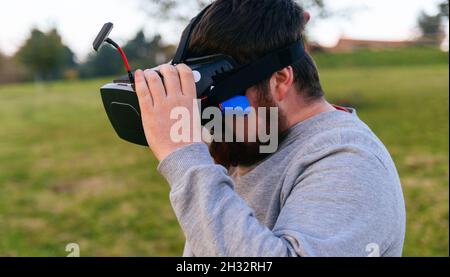 Homme tenant ses lunettes de réalité virtuelle pour voler son drone fpv. Banque D'Images