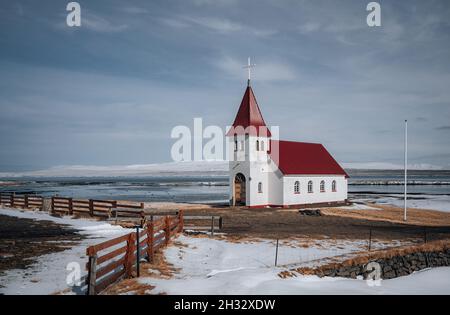 Église islandaise rurale typique sous un ciel bleu nuageux en hiver avec de la neige.Tir horizontal. Banque D'Images