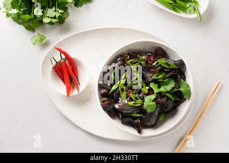 Salade de champignons noirs d'arbre marinés dans un bol sur fond blanc.Vue de dessus.Cuisine chinoise et asiatique. Banque D'Images