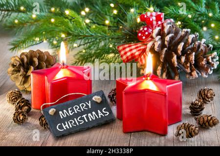 Étiquette de joyeux Noël et décoration rouge avec bougies et cônes de sapin Banque D'Images