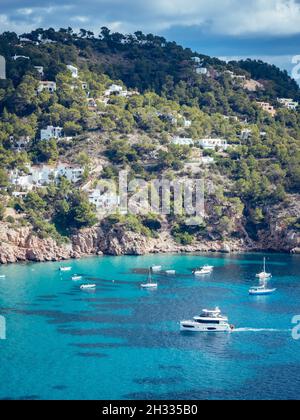 IBIZA, ESPAGNE - 14 octobre 2020 : la belle eau azur de l'île d'Ibiza avec des navires et des bateaux entourés de falaises rocheuses Banque D'Images