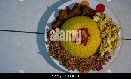 La cuisine indonésienne traditionnelle « Nasi Kuning » sur l'assiette Banque D'Images