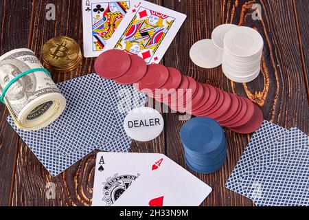 Jetons de poker avec des cartes et de l'argent sur un bureau en bois. Banque D'Images