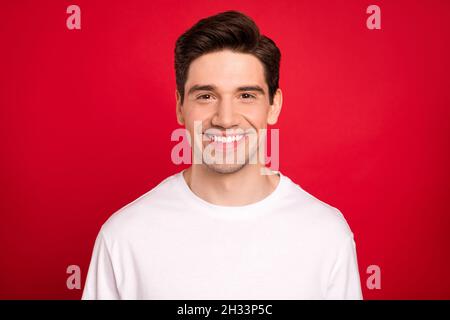 Photo portrait souriant Happy brunet portant un t-shirt décontracté isolé couleur rouge vif arrière-plan Banque D'Images