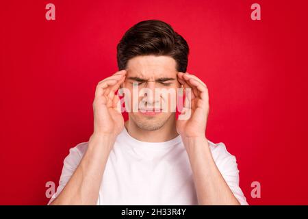 Photo portrait brunet en chemise blanche a eu mal de tête ont besoin de pilules isolé rouge vif couleur arrière-plan Banque D'Images