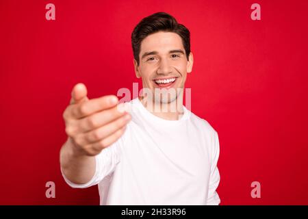 Photo portrait brunet en blanc chemise amicale demandant du suivre isolé rouge vif arrière-plan de couleur Banque D'Images