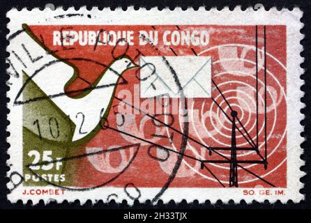 CONGO - VERS 1965: Timbre imprimé au Congo consacré à la création de l'administration postale nationale, emblèmes de communication, vers 1965 Banque D'Images