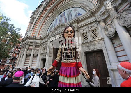 Londres, Angleterre, Royaume-Uni.25 octobre 2021.« Little Amal » visite la cathédrale de Westminster.la marionnette de 3.5 mètres de haut représentant une jeune fille syrienne migrante a presque terminé son voyage de 8 000 km en Europe, à partir de Gaziantep, en Turquie, qui a culminé à Manchester, en Angleterre, début novembre.(Image de crédit : © Tayfun Salci/ZUMA Press Wire) Banque D'Images