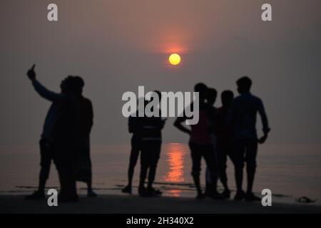 Patuakhali, Bangladesh.22 octobre 2021.Les touristes apprécient le soleil levant à la plage de Kuakata dans le district de Patuakhali du Bangladesh.Kuakata est l'un des rares endroits naturels qui offre une vue complète de la montée et le coucher du soleil sur la baie du Bengale.Une destination touristique populaire, il est à environ 320 kilomètres au sud de Dhaka, la capitale du Bangladesh.Crédit : SOPA Images Limited/Alamy Live News Banque D'Images