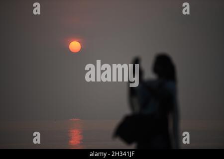 Patuakhali, Bangladesh.22 octobre 2021.Un touriste apprécie le soleil levant à la plage de Kuakata dans le district de Patuakhali du Bangladesh.Kuakata est l'un des rares endroits naturels qui offre une vue complète de la montée et le coucher du soleil sur la baie du Bengale.Une destination touristique populaire, il est à environ 320 kilomètres au sud de Dhaka, la capitale du Bangladesh.(Image de crédit : © Piyas Biswas/SOPA Images via ZUMA Press Wire) Banque D'Images