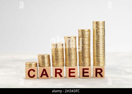 Carrière.Croissance des salaires et des revenus avec un bon emploi.Des piles de pièces d'or, des marches vers le haut, sur les cubes DE CARRIÈRE. Banque D'Images