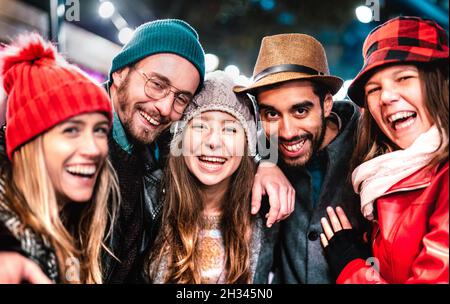 Les gars et les filles les plus grands amis prennent le selfie sur des vêtements chauds de mode la nuit - concept de style de vie heureux avec les gens de la vie de se divertir ensemble en plein air Banque D'Images