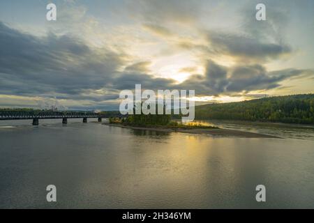 Fleuve Fraser au confluent avec la rivière Nechako près de la ville de Prince George et le pont CN de Prince George en arrière-plan. Banque D'Images