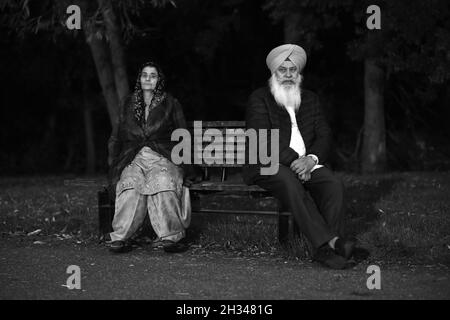 Homme indien portant le turban et femme assise sur le banc de parc public lors des célébrations de Diwali Grande-Bretagne octobre 2021 Banque D'Images